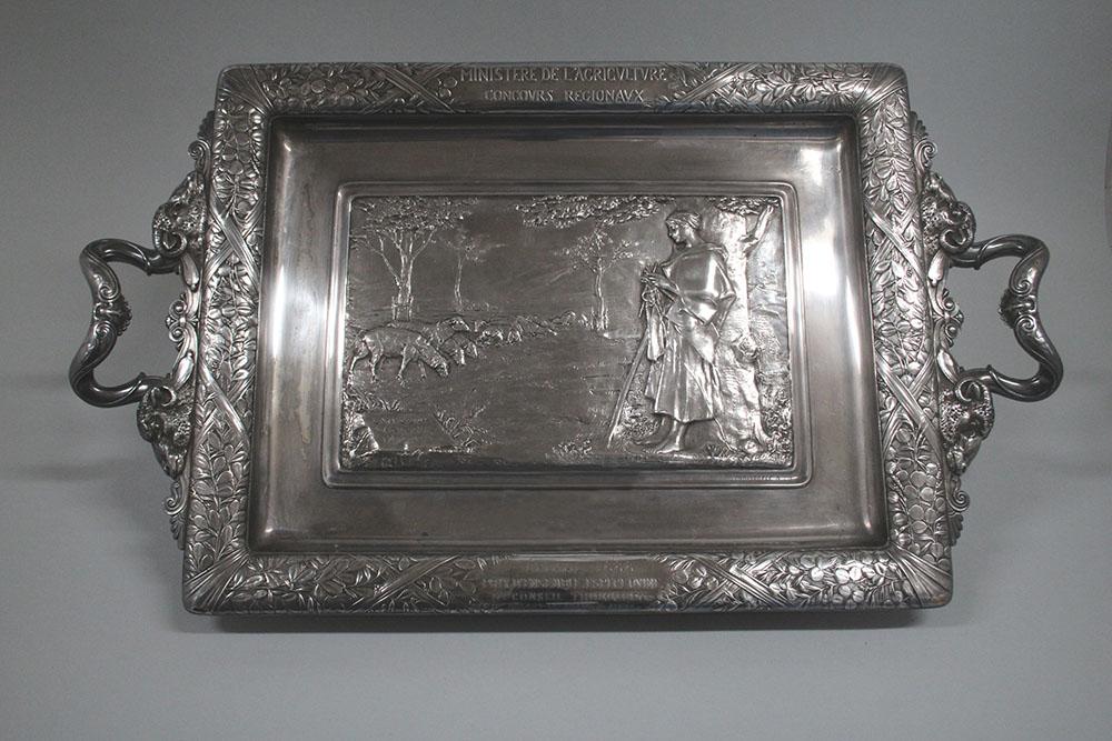 Plateau à anses en métal argenté, décoré par un relief représentant une bergère avec son troupeau de moutons. 