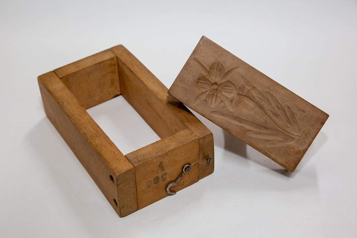 Moule et marque à beurre en bois, de forme rectangulaire, la marque sculptée en creux représente une fleur.