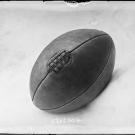 Photographie de presse datée de 1907, en noir et blanc, représentant un ballon de rugby, couture vers le haut.