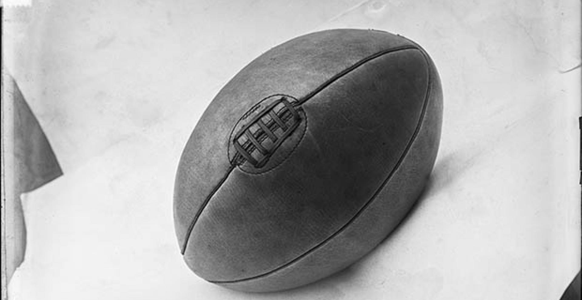 Photographie de presse datée de 1907, en noir et blanc, représentant un ballon de rugby, couture vers le haut.