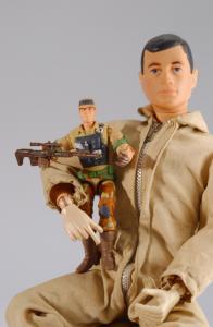 Gi-Joe ® Hasbro, tient dans ses bras une figurine GI-Joe en tenue de combat