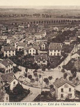 Carte postale ancienne, représentant la cité des cheminots à Brou-sur-Chantereine. La cité, composée de maisons avec jardin est organisée autour d'une place ronde.