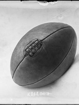 Photographie de presse datée de 1907, en noir et blanc, représentant un ballon de rugby, couture vers le haut.