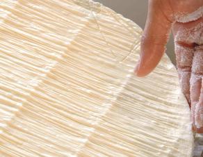 photo prise à la fromagerie de Saint Siméon : le salage manuel du fromage
