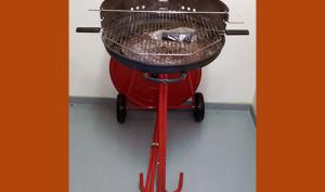 Barbecue à charbon de bois, composé d'un support en métal laqué muni de deux roues en plastique, supportant une cuve en métal dans laquelle on place le charbon de bois. et