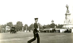 Tirage gélatino-argentique sur papier baryté brillant daté de 1934. Vue de Londres :  Un militaire traverse la chaussée devant Buckingham Palace et le Victoria Memorial.