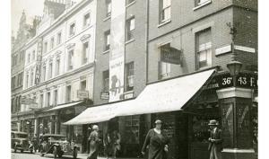 Vue de Londres, datée de 1934 : une rue animée avec voitures et personnages. Photographie rapportée de Londres par Pierre Mac Orlan à l'occasion d'un de ses reportages.