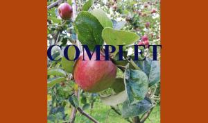Gros plan d'une pomme, sur une branche de pommier, dans un verger. Par dessus la photographie, la mention "complet" pour informer le public que le nombre maximum d'inscrits est atteint.