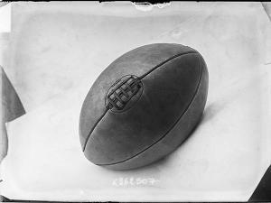 Photographie de presse datée de 1907, en noir et blanc, représentant un ballon de rugby, couture vers le haut.