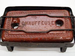 Chaufferette en terre cuite réfractaire vernissée, de forme rectangulaire, posée dans un piétement en métal