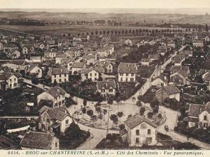Carte postale ancienne, représentant la cité des cheminots à Brou-sur-Chantereine. La cité, composée de maisons avec jardin est organisée autour d'une place ronde.