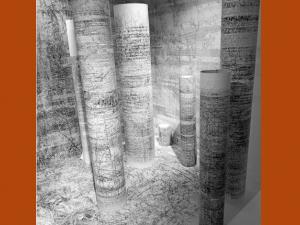 Oeuvre de Bertrand Flachot constituée de rouleaux de papier couverts de dessins et d'écriture, sur un fond en papier également recouvert d'inscriptions à l'encre noire.