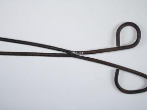 Fer à tuyauter de repasseuse ; instrument en métal, à longues branches articulées et fines, dont la forme rappelle une paire de ciseaux