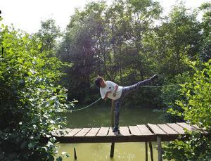 Tilotama, animatrice sportive en situation de handicap, effectue une démonstration de parataekwondo sur un ponton surplombant un plan d'eau.
