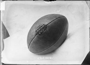 Photographie de presse datée de 1907, en noir et blanc, représentant un ballon de rugby, couture vers le haut.