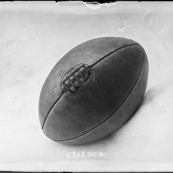 Photographie de presse datée de 1907, en noir et blanc, représentant un ballon de rugby, couture vers le haut.