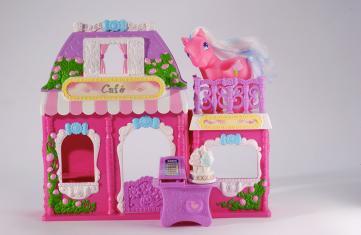 Petit Poney ® Hasbro, le poney de couleur rose est installé sur le toit-terrasse d'un café en plastique de couleur rose et mauve