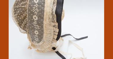 Coiffe en tulle de coton rebrodé de plumetis et de broderies blanches, volant de dentelle au fuseau orné de plis plats avec une sous coiffe de couleur noire.