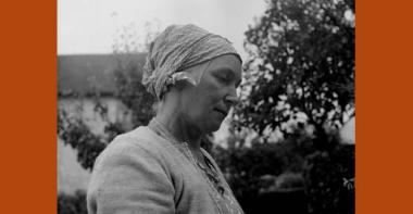 Photographie d'une femme coiffée d'un carré de coton gris noué sur la chevelure, communément appelé marmotte.