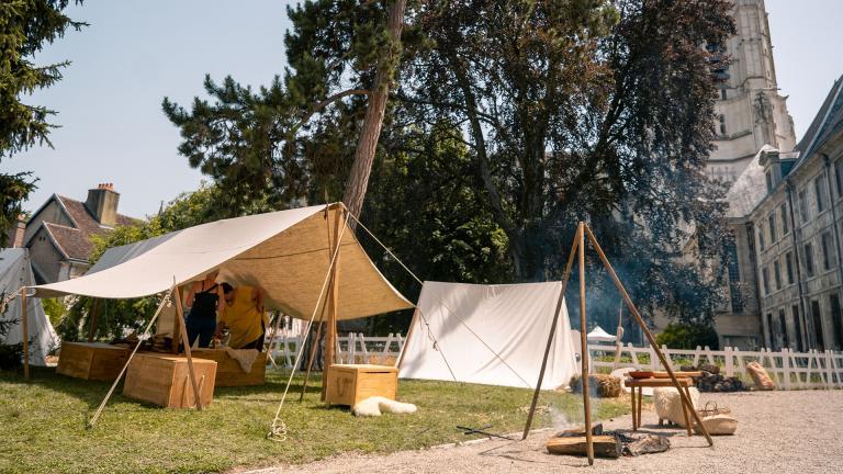 photographie couleur d'un campement installé par l'association Branno Teuta à l'arrière d'une abbaye.