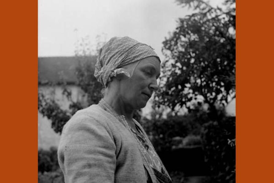 Photographie d'une femme coiffée d'un carré de coton gris noué sur la chevelure, communément appelé marmotte.