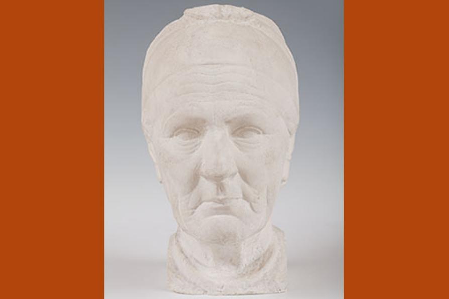 Sculpture en plâtre représentant la tête d'une vieille femme briarde ; ses traits sont marqués, ses cheveux plaqués en arrière par un bandeau.